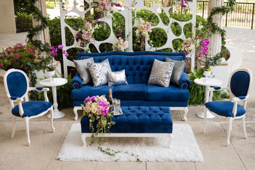 Blue velvet lounge seating with flowers and garden greenery